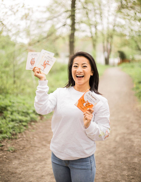 Femme asiatique entrepreneure de Les Bougeottes tenant des cartes de gymnastique pour enfant dans ces mains
