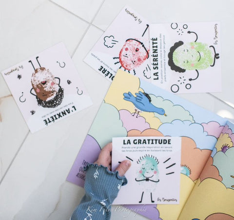 Enfant tenant une carte d'émotion d'un livre interactif sur les émotions pour l'apprentissa des émotions par le mouvement.
