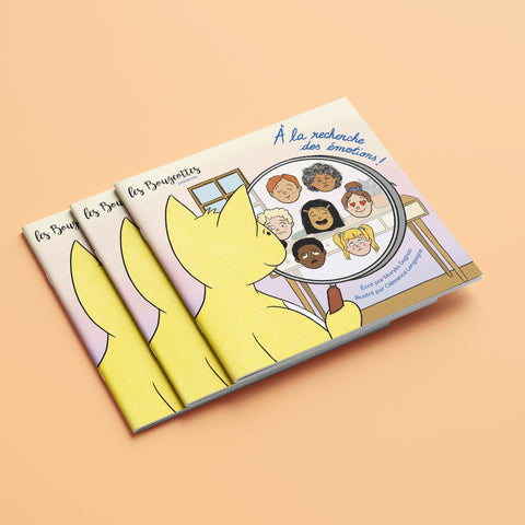 Plusieurs livres interactifs pour enfants sur le thème des émotions, empilés les uns sur les autres sur un fond orange.