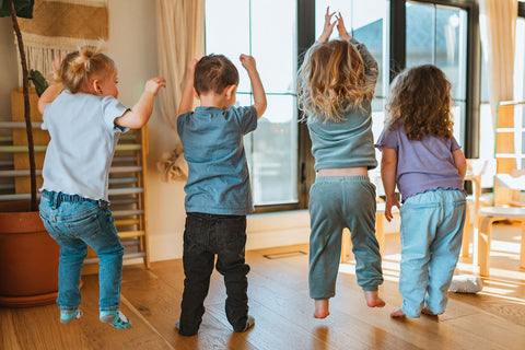 Groupe d'enfants en petite enfance qui sautent dans une garderie