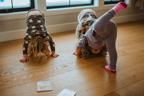 Des enfants de la petite enfance qui font de la gymnastique dans une garderie avec des cartes de gymnastique au sol. 