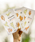 Main tenant trois feuilles d’autocollants Les Bougeottes en nature, mascottes renard et kangourou en mouvements de gymnastique.
